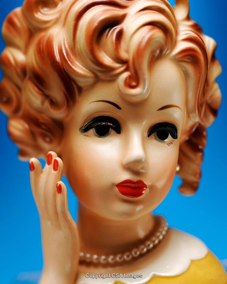 Vintage Ceramic Figurine With Retro Hairstyle And Red Lips on Blue Background