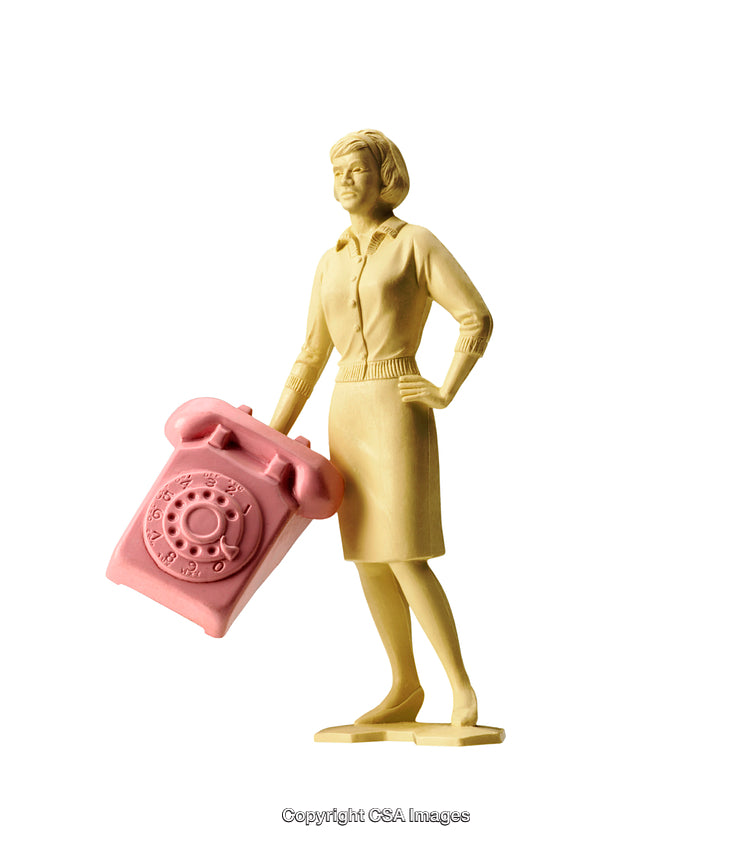Yellow Figurine Holding Pink Rotary Telephone Isolated on White