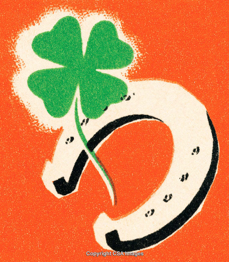 Four-Leaf Clover and Horseshoe on Orange Background Symbolizing Luck and Prosperity