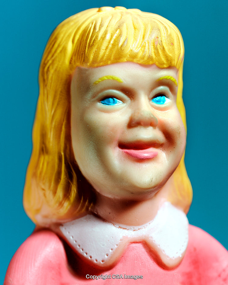 Vintage Plastic Doll Figurine with Blonde Hair and Pink Outfit on Blue Background