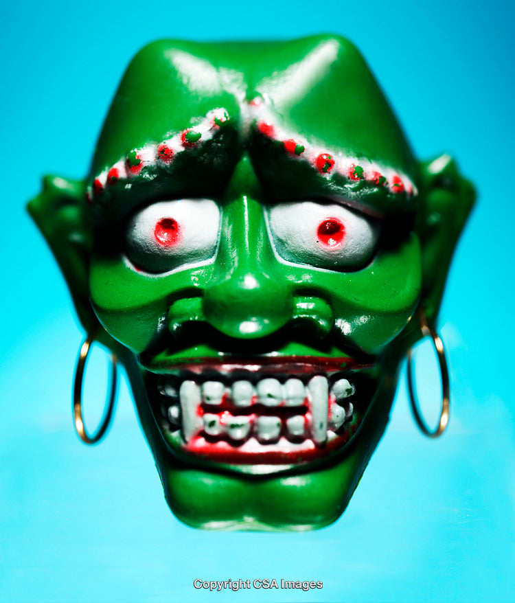 Green Plastic Monster Figurine with Vibrant Colors on Blue Background