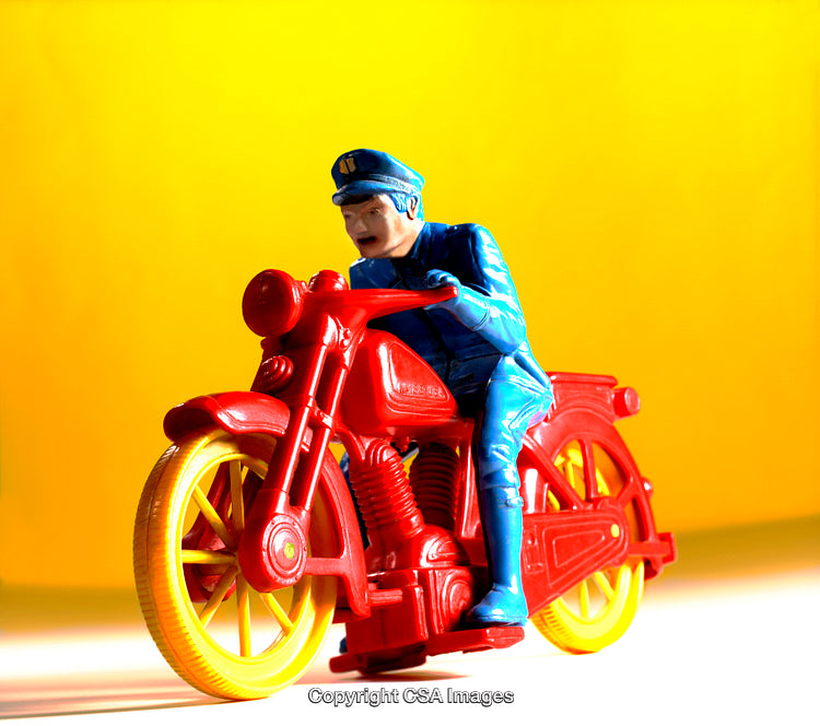 Vintage Red Plastic Toy Motorcycle With Policeman On Yellow Background