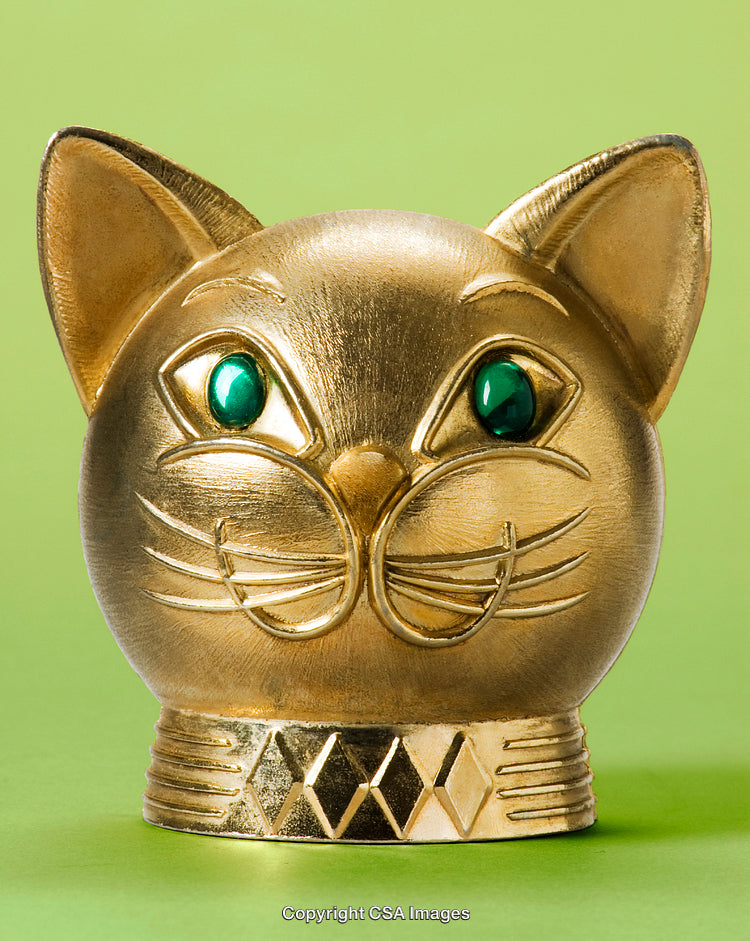 Golden Cat Figurine with Emerald Eyes on a Vibrant Green Background