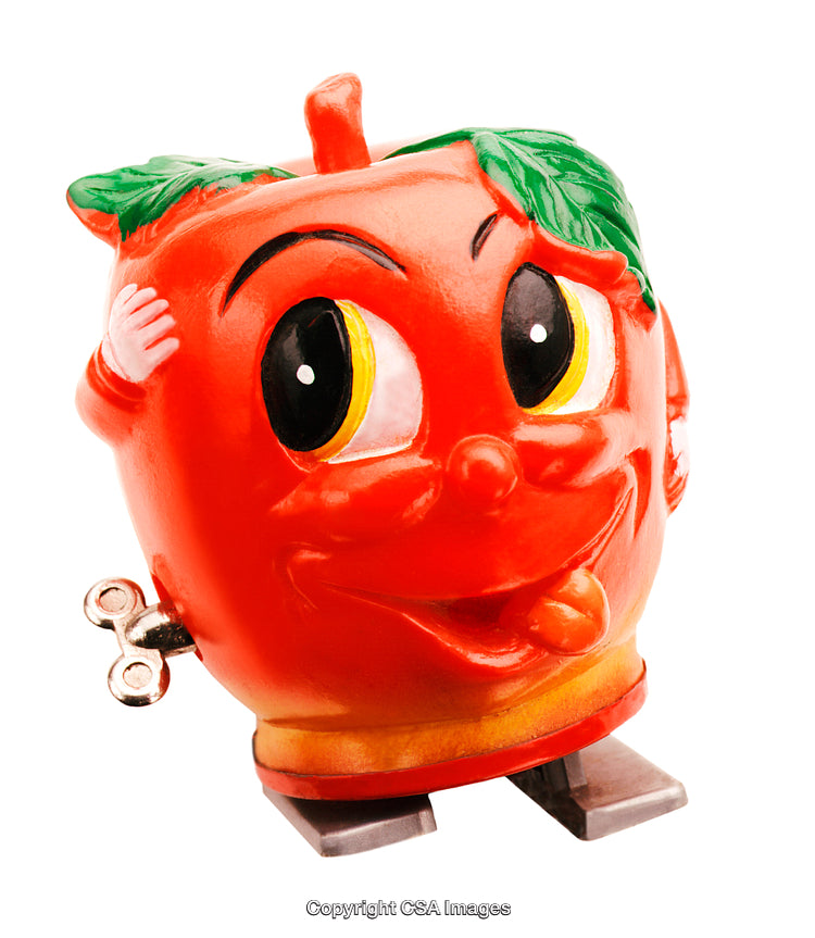 Close-Up of a Retro Wind-Up Toy Shaped Like a Happy Apple