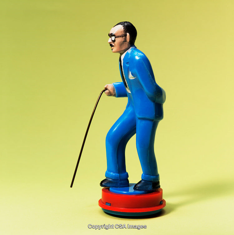 Plastic Figurine in Blue Suit with Cane Against Yellow Background