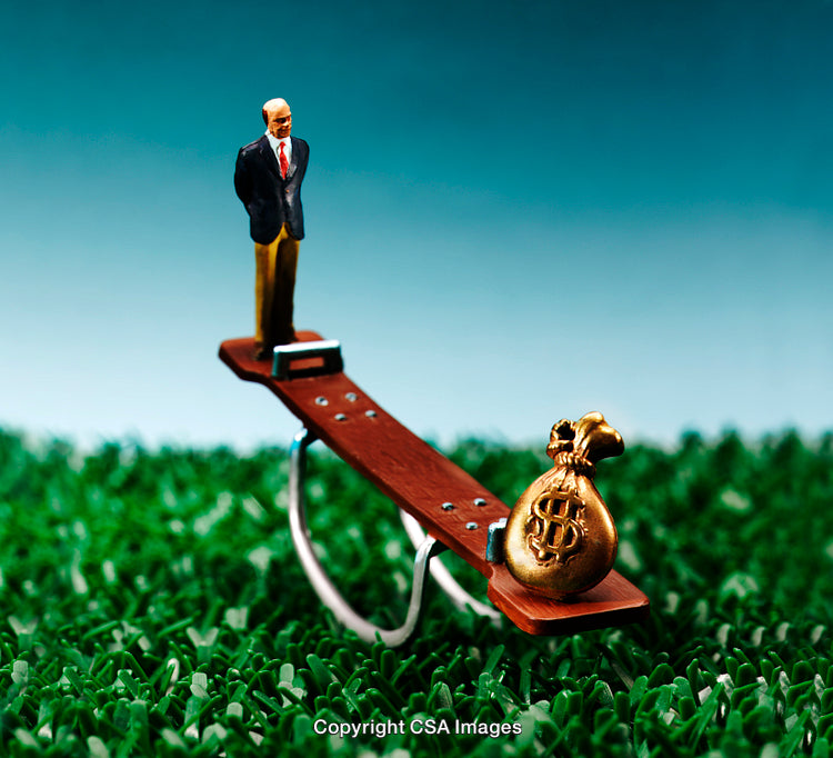 Miniature Businessman on Seesaw Balancing Against a Bag of Wealth