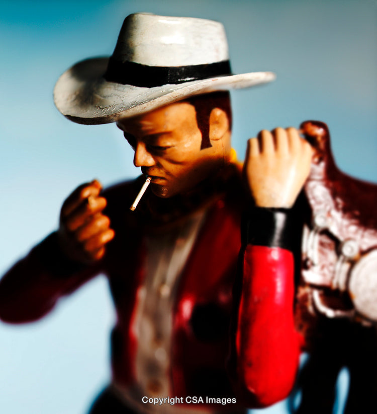 Close-Up of Cowboy Figurine with Cigarette and Saddle in Hand