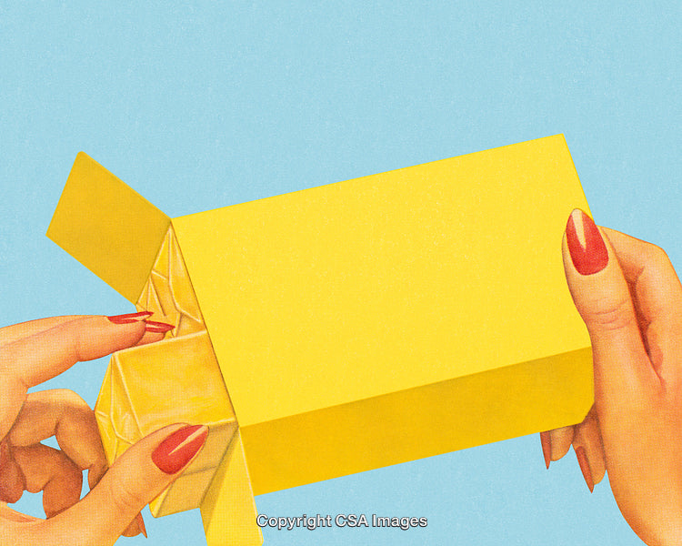 Close-Up of Hands Extracting Item From Bright Yellow Box on Blue Background