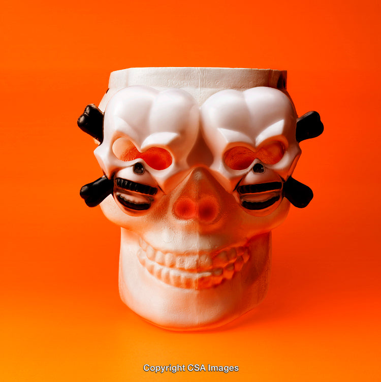 Styled Plastic Skull on Vibrant Orange Background for Halloween Celebration Themes