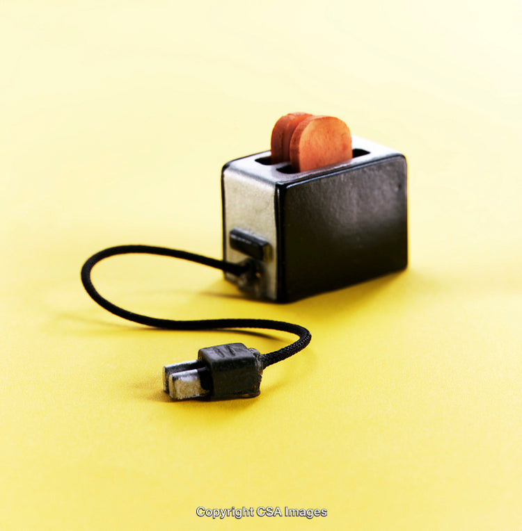 Miniature Toaster Toy with Cable on a Yellow Background