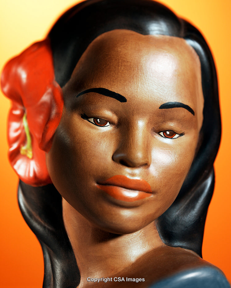 Close-Up of Female Figurine with Floral Accessory on Orange Background