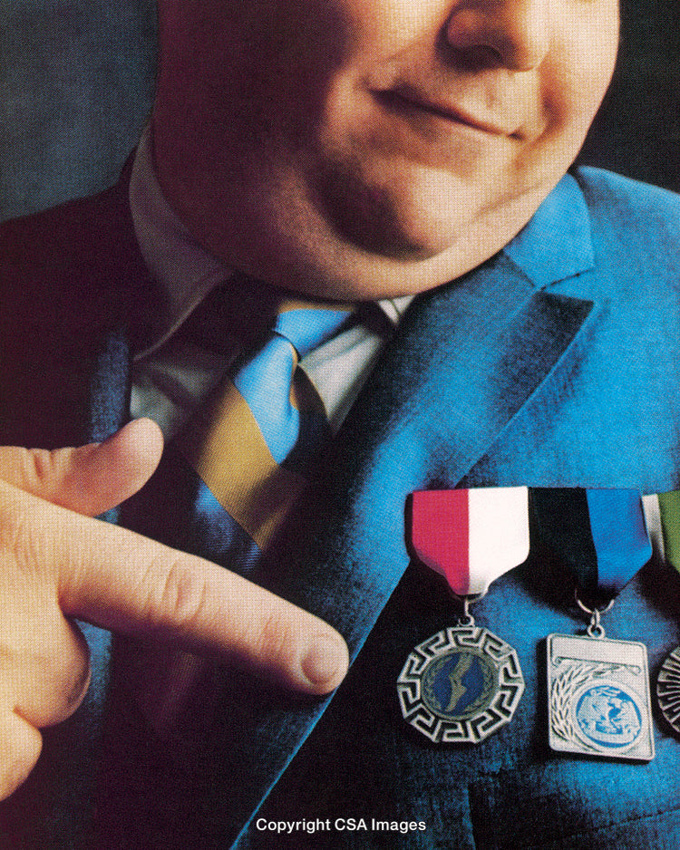 Businessman Showcasing Awards With a Confident Gesture in a Formal Suit