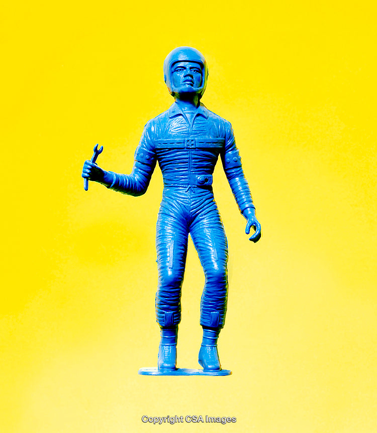 Blue Plastic Astronaut Figure Against Yellow Background