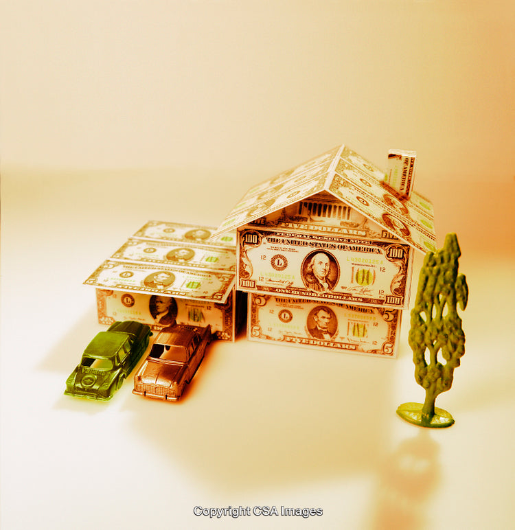 Dollar Bill House With Toy Cars and Tree Against Orange Background