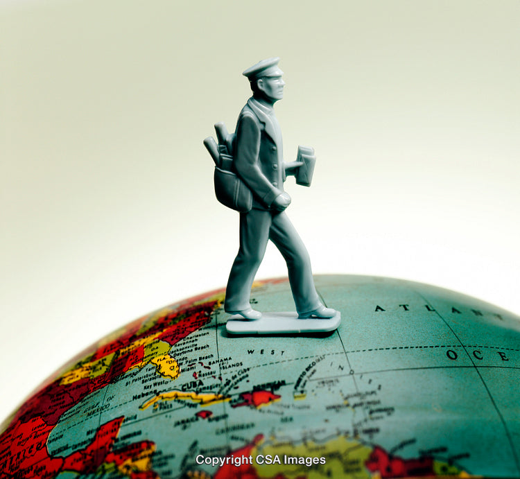 Plastic Toy Figure of a Traveler Stands on a Colorful Globe