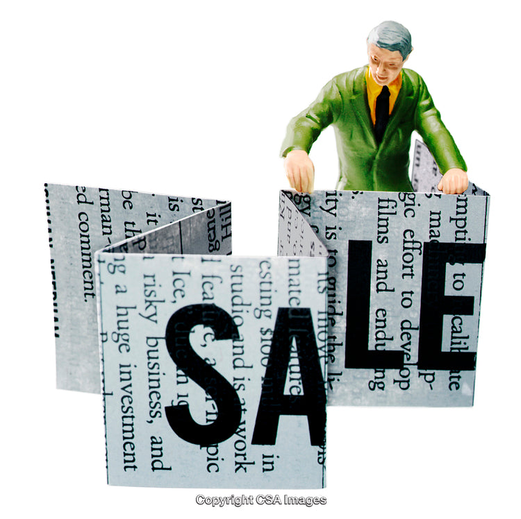 Business Figurine Exploring Newspaper Block Structure with Sale Text