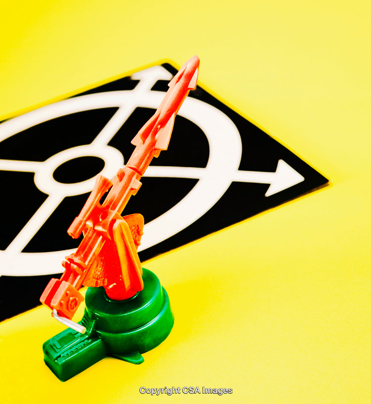 Colorful Plastic Toy Rocket on Yellow Background with Target Symbol