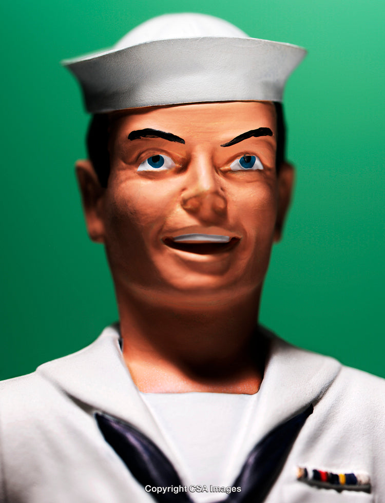 Close-Up of Sailor Toy Figurine Against Green Background