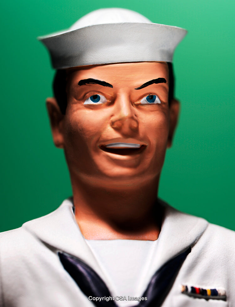 Close-Up of Sailor Toy Figurine Against Green Background