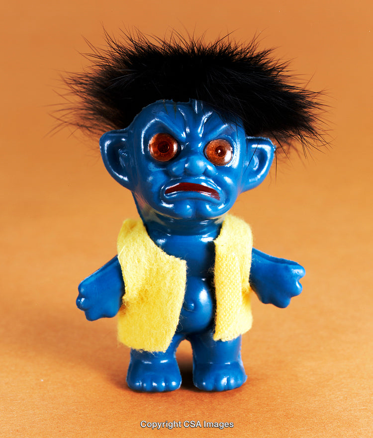 Close-Up of Blue Plastic Toy Figurine With Yellow Jacket on Orange Background