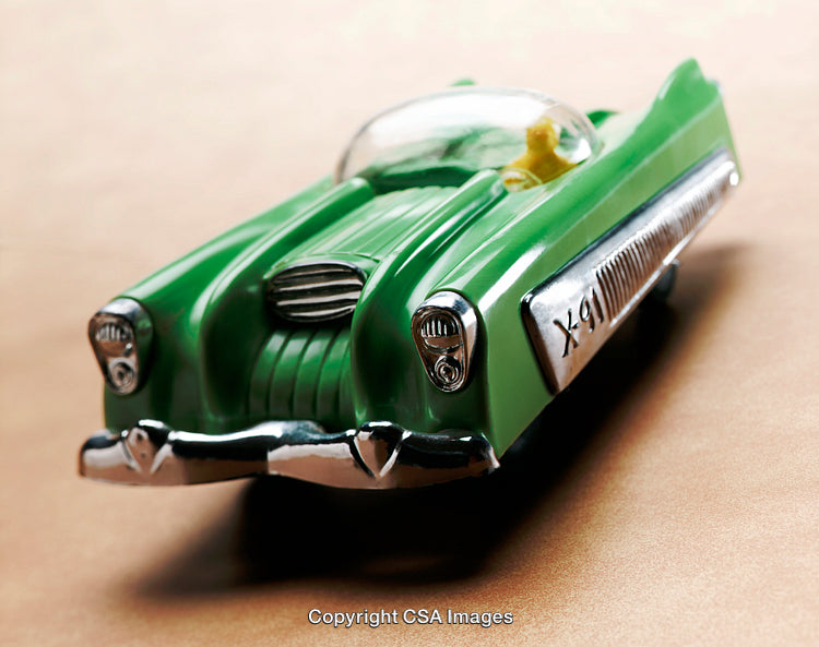 Vintage Green Toy Car With Chrome Details on a Beige Surface