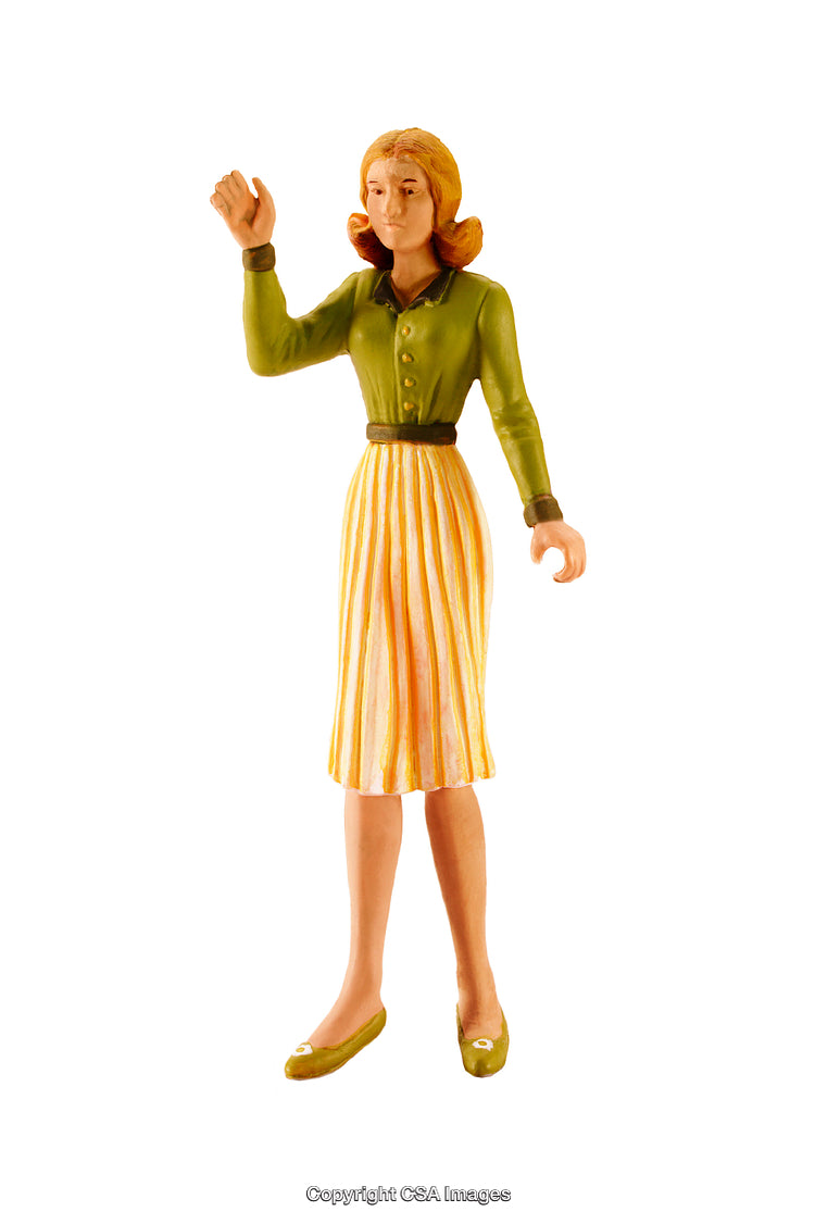 Plastic Figurine of Woman in Green and Yellow Outfit on White Background