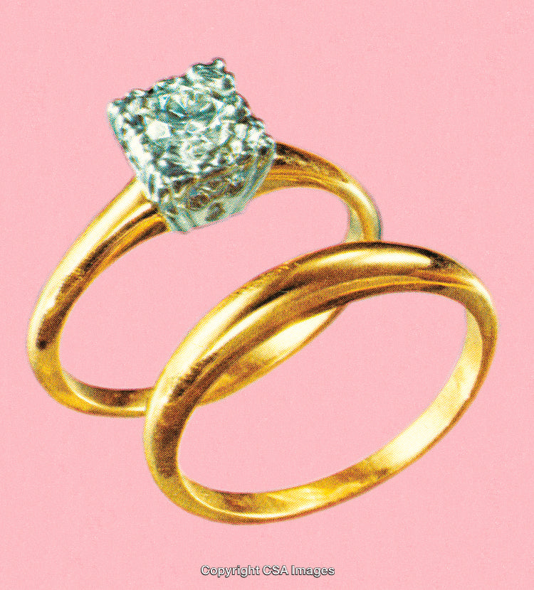 Close-Up of Golden Rings with Diamond on Pink Background