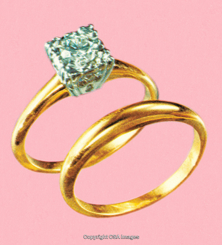 Close-Up of Golden Rings with Diamond on Pink Background