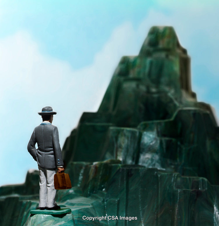 Miniature Figure Facing A Scenic Mountain Representing Ambition and Adventure