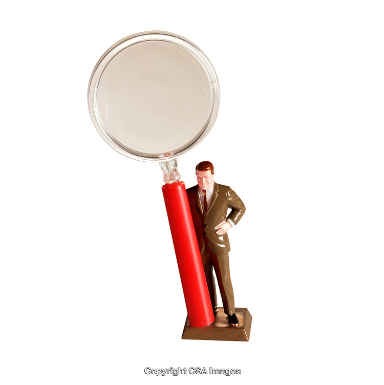 Toy Businessman Beside Large Magnifying Glass on White Background