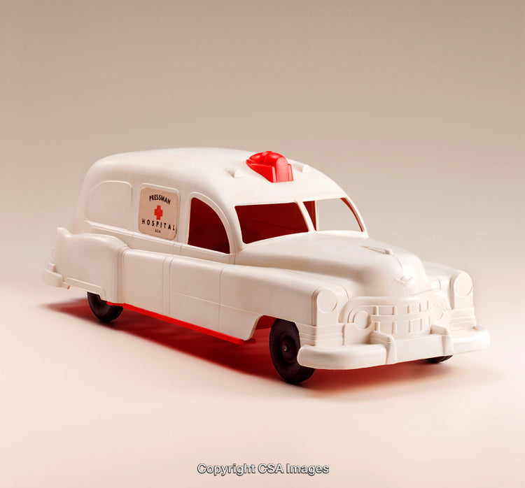 Vintage White Plastic Toy Ambulance with Red Siren Isolated on Beige