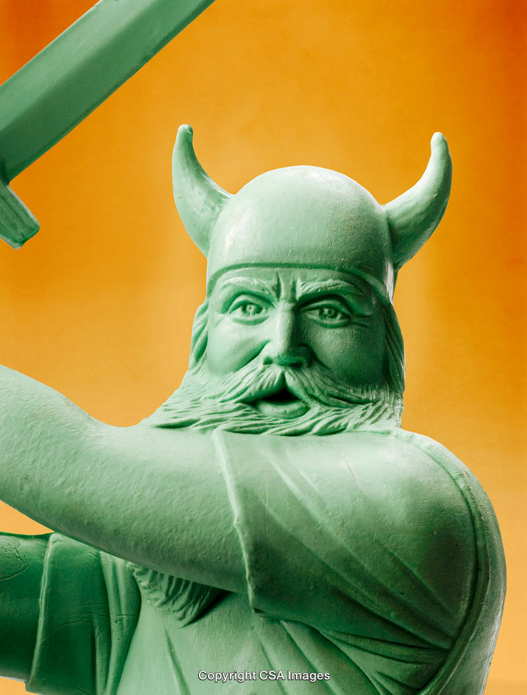 Close-Up of Green Viking Character Figure with Sword on Orange Background