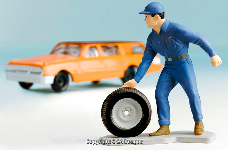 Miniature Repairman and Orange Car Scene on White Surface