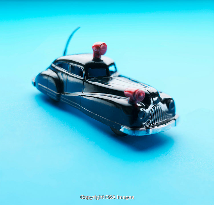 Vintage Toy Police Car on Blue Background with Red Sirens
