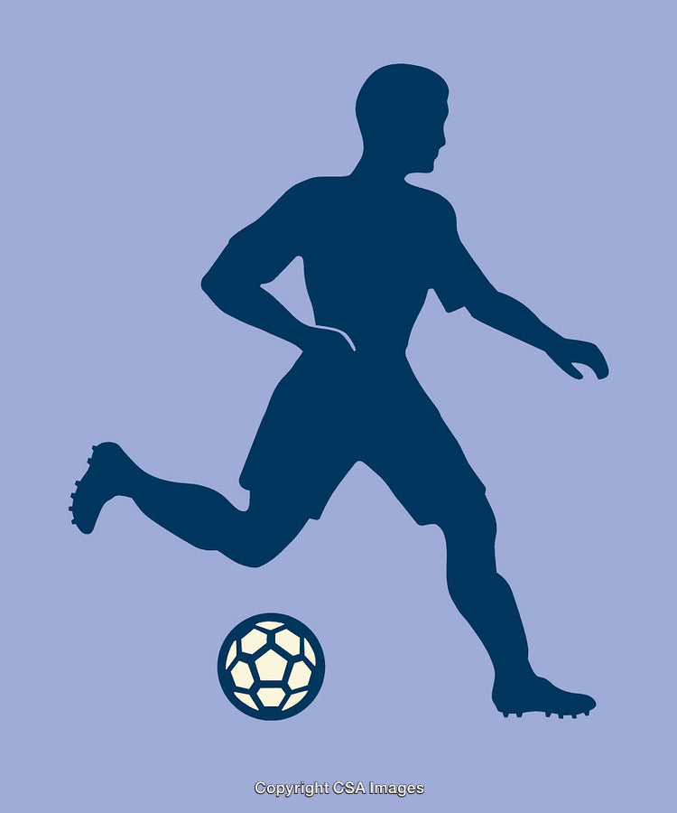 Silhouette of a Soccer Player Kicking a Ball in Motion