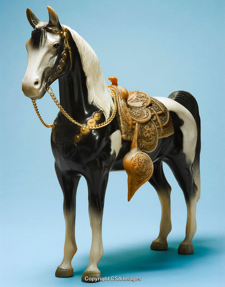 Detailed Plastic Horse Toy with Saddle and Golden Accessories on Blue Background