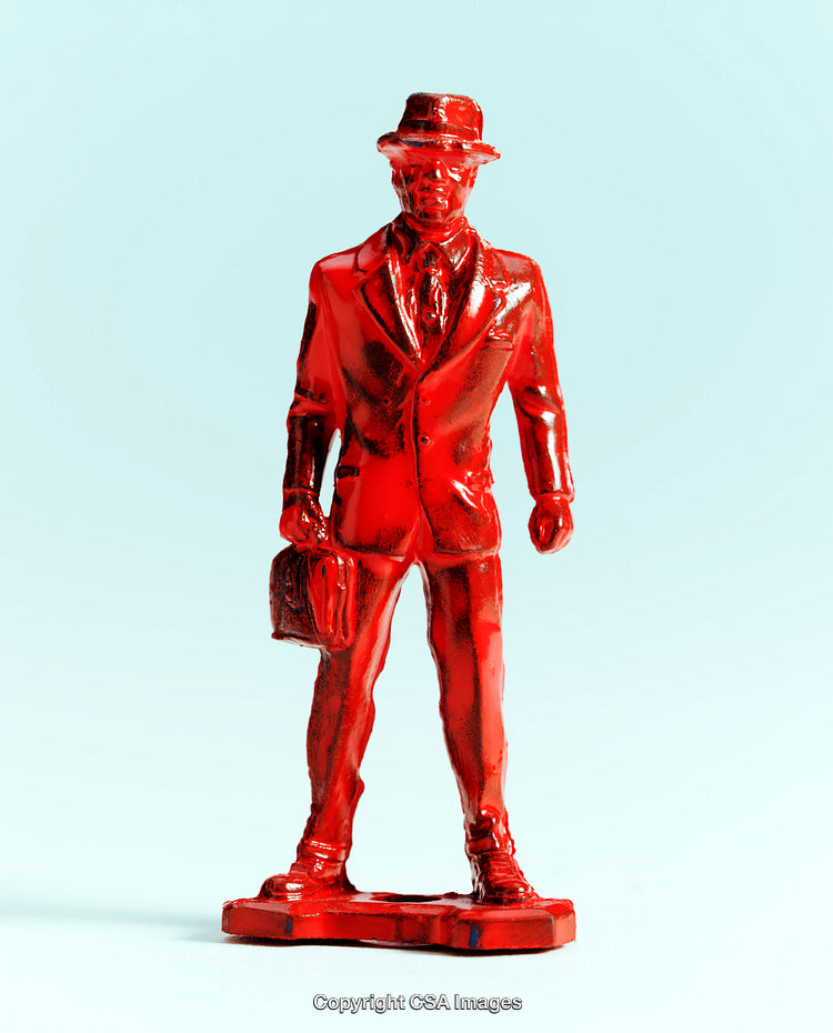 Red Painted Plastic Businessman Figure on Light Gradient Background