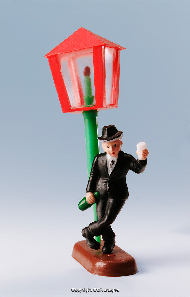 Miniature Toy Figure of a Gentleman Leaning on a Street Lamp