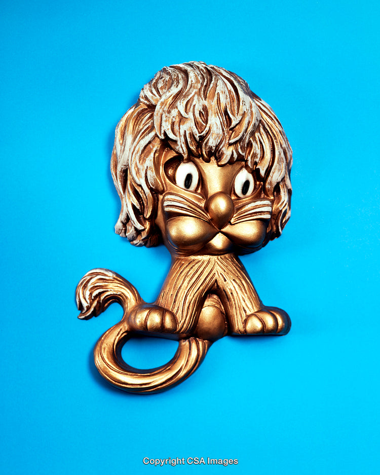 Golden Lion Figurine On Vibrant Blue Background Displaying Playful Design