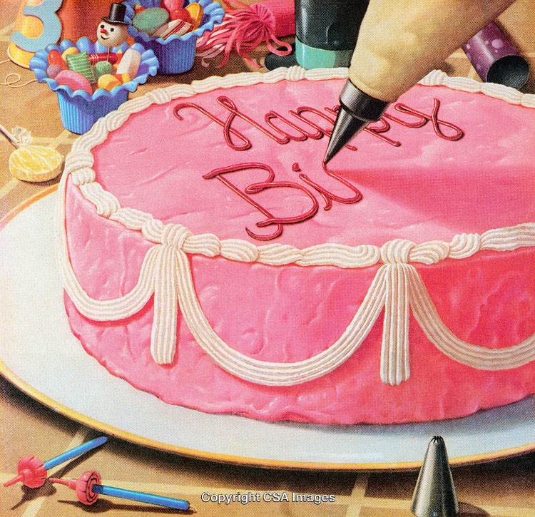 Pink Birthday Cake Being Decorated with Frosting and Party Decorations Around