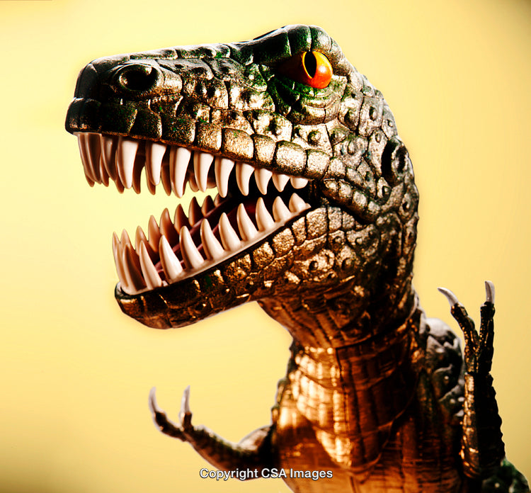 Close-Up of a Dinosaur Figurine With Open Jaws on Yellow Background
