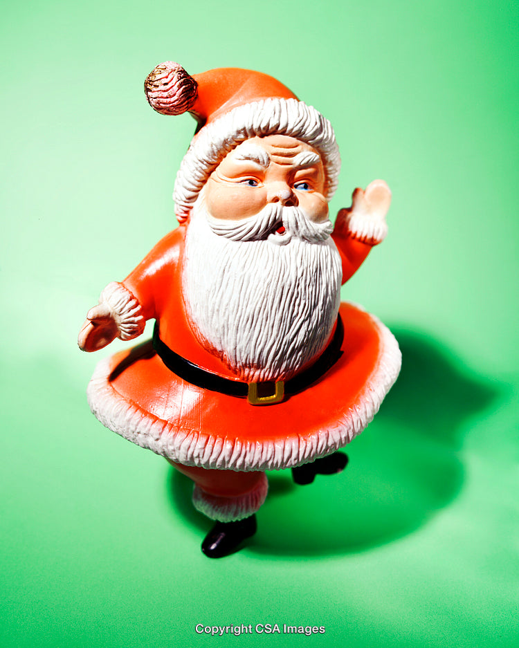 Colorful Santa Claus Toy Figurine Against a Vibrant Green Background
