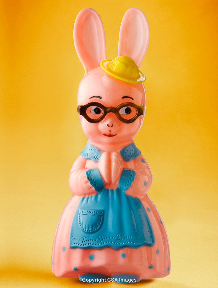 Pink Plastic Rabbit Toy with Blue Apron on Yellow Background