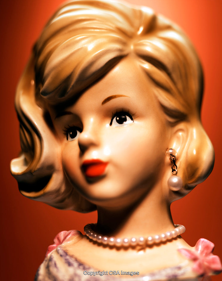Elegant Porcelain Figurine With Pearl Accessories Against a Red Background