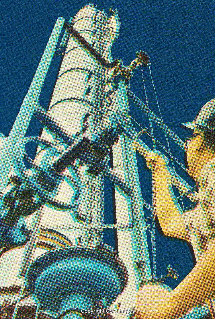 Engineer Working on Industrial Equipment Against a Clear Blue Sky