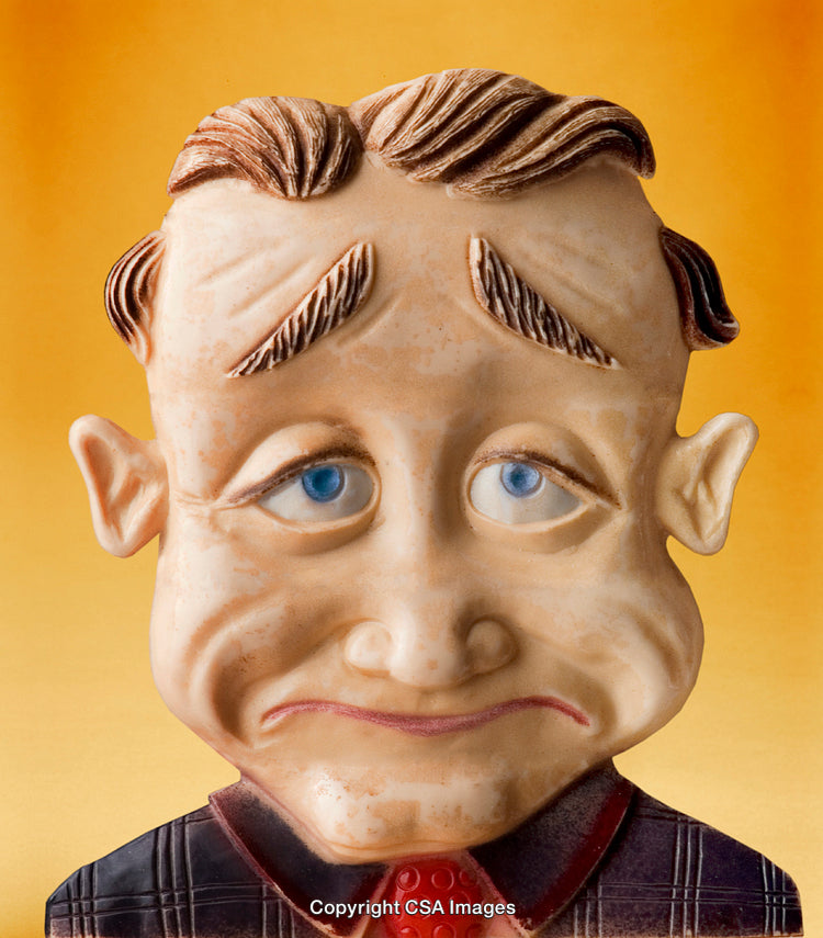 Close-Up of a Sad Expression Toy Figure on a Yellow Background