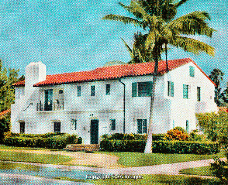 Vintage Spanish Colonial Style Home with Palm Trees and Blue Sky