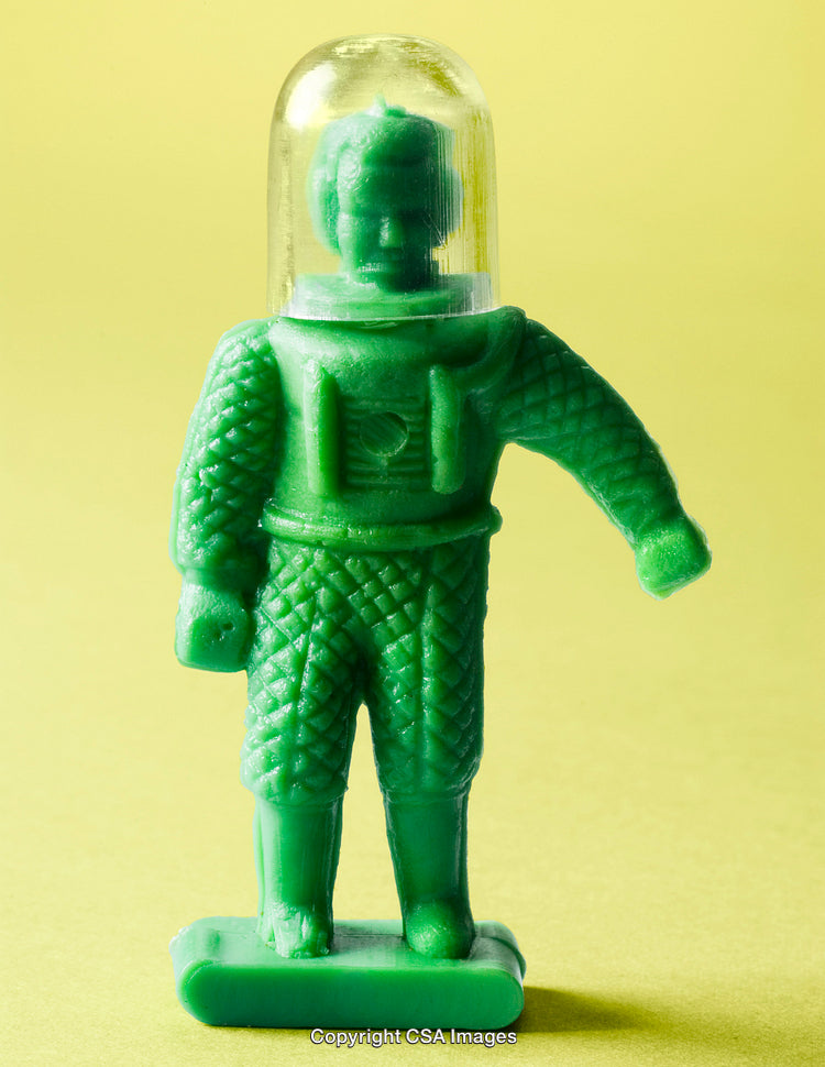 Vintage Green Plastic Space Toy Figurine on a Yellow Background