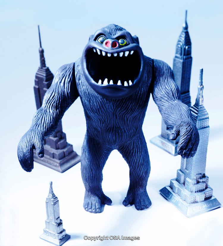 Giant Monster Toy Among Tiny Skyscraper Models in Dramatic Scene