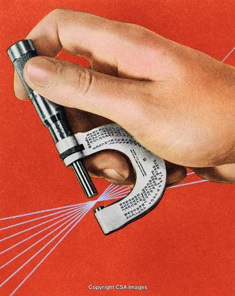 Hand Holding Micrometer on Retro Background Demonstrating Precision Measurement